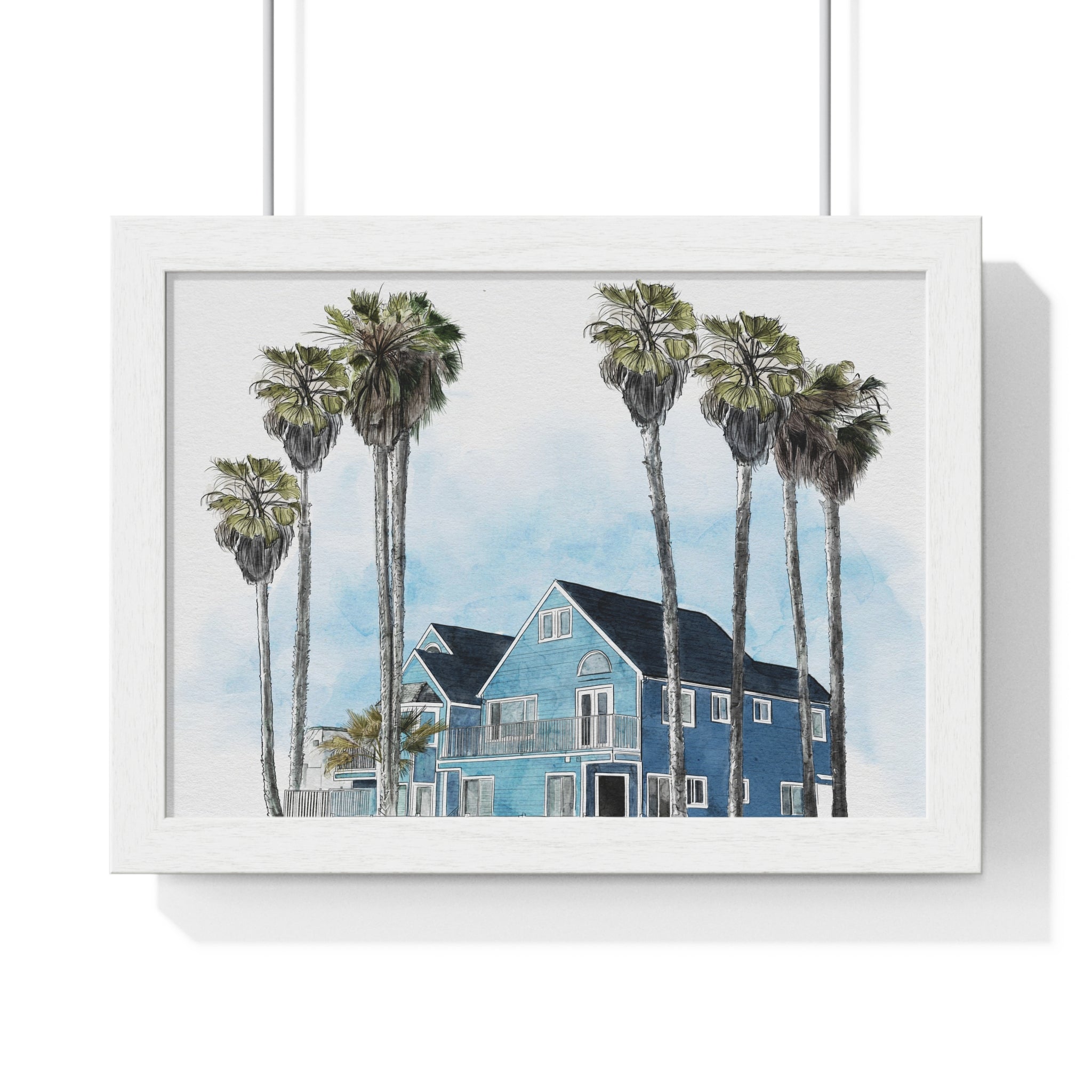 Framed artwork of a blue house with palm trees on a white background